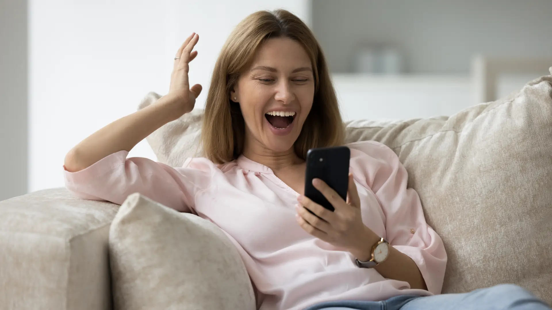 Mujer contenta después de ver los celulares baratos mas vendidos