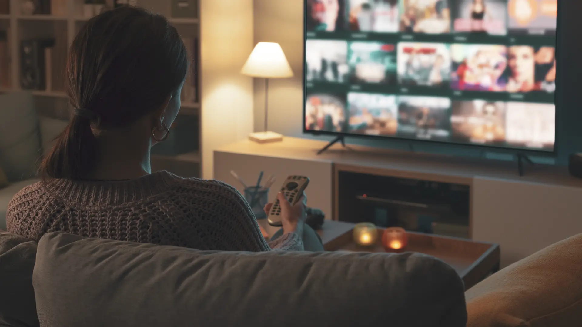 Mujer tranquila en su casa viendo la televisión gracias a Claro Video