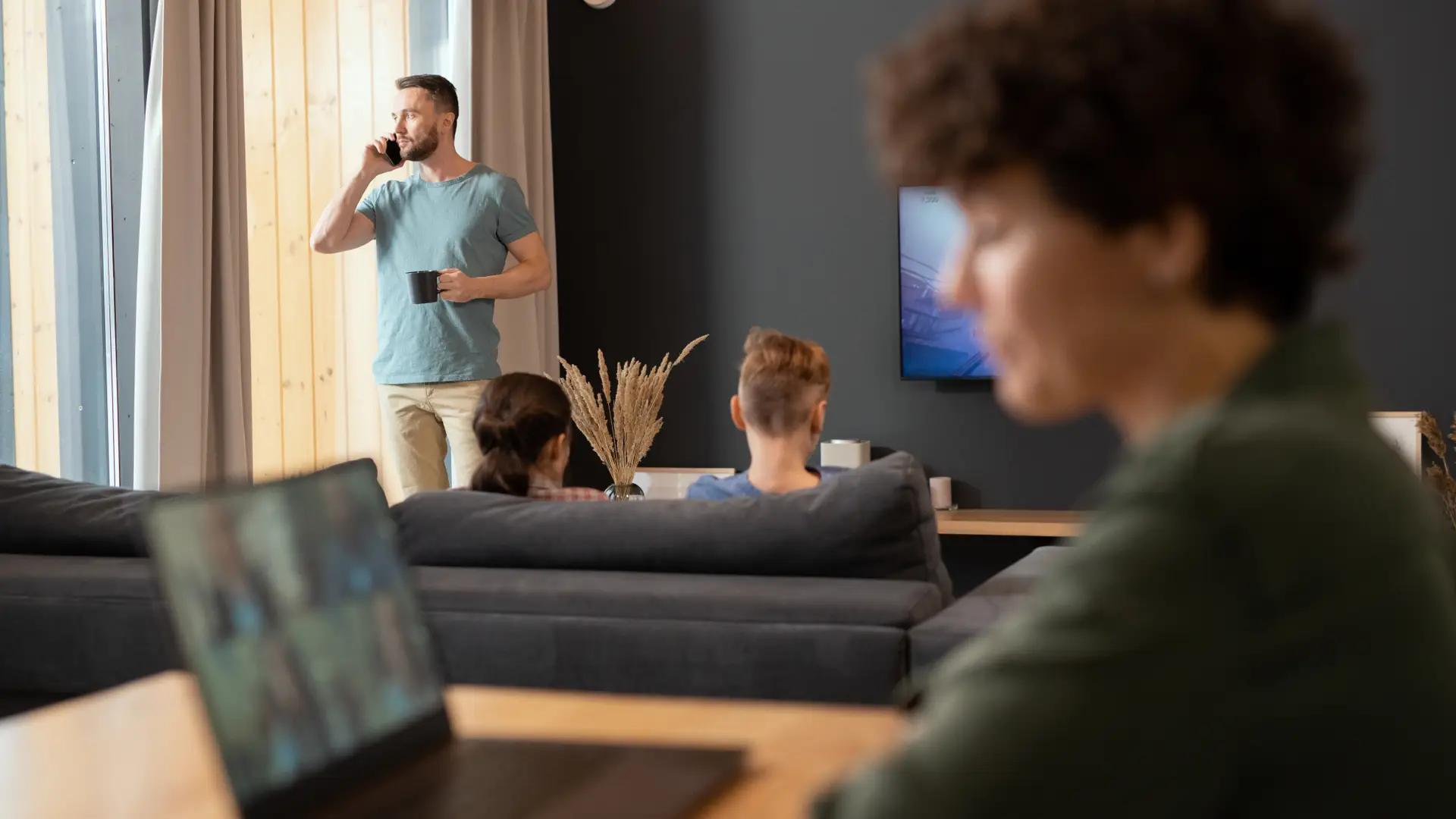 Familia que ve la tele y está con el movil y el ordenador gracias a los planes de internet de Claro
