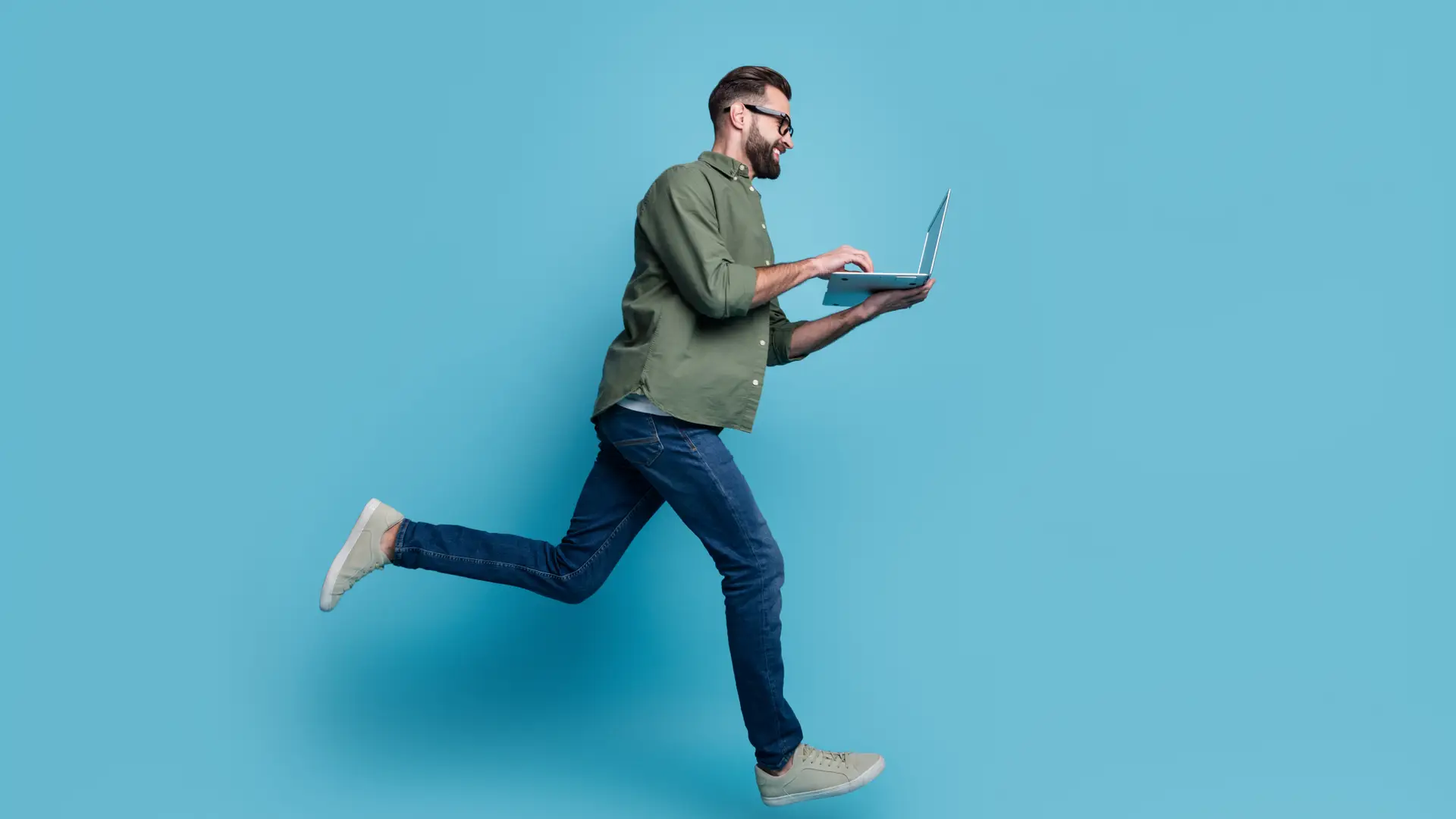 Un hombre saltando con su ordenador que esta haciendo la portabilidad con Movistar