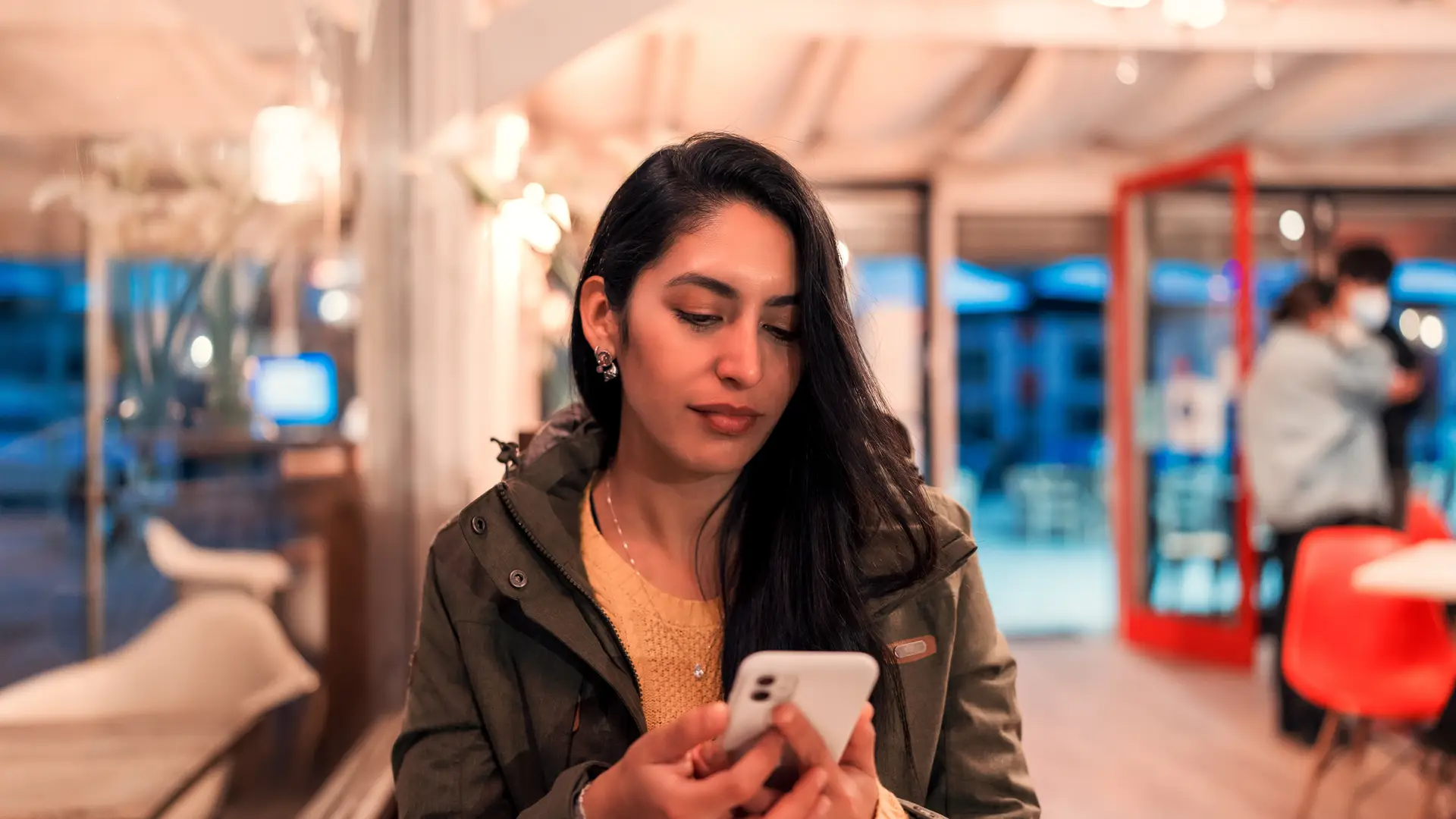 Una joven en su celular revisando los derechos de los clientes de Virgin Mobile